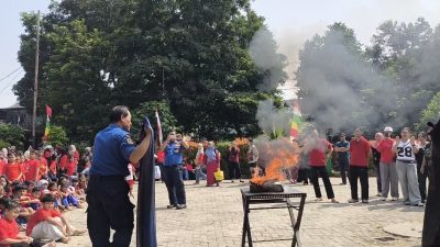 Petugas Damkar Jatinegara memperagakan teknik pemadaman api menggunakan handuk basah di hadapan siswa SDN 09 Cipinang Besar Utara Jakarta Timur