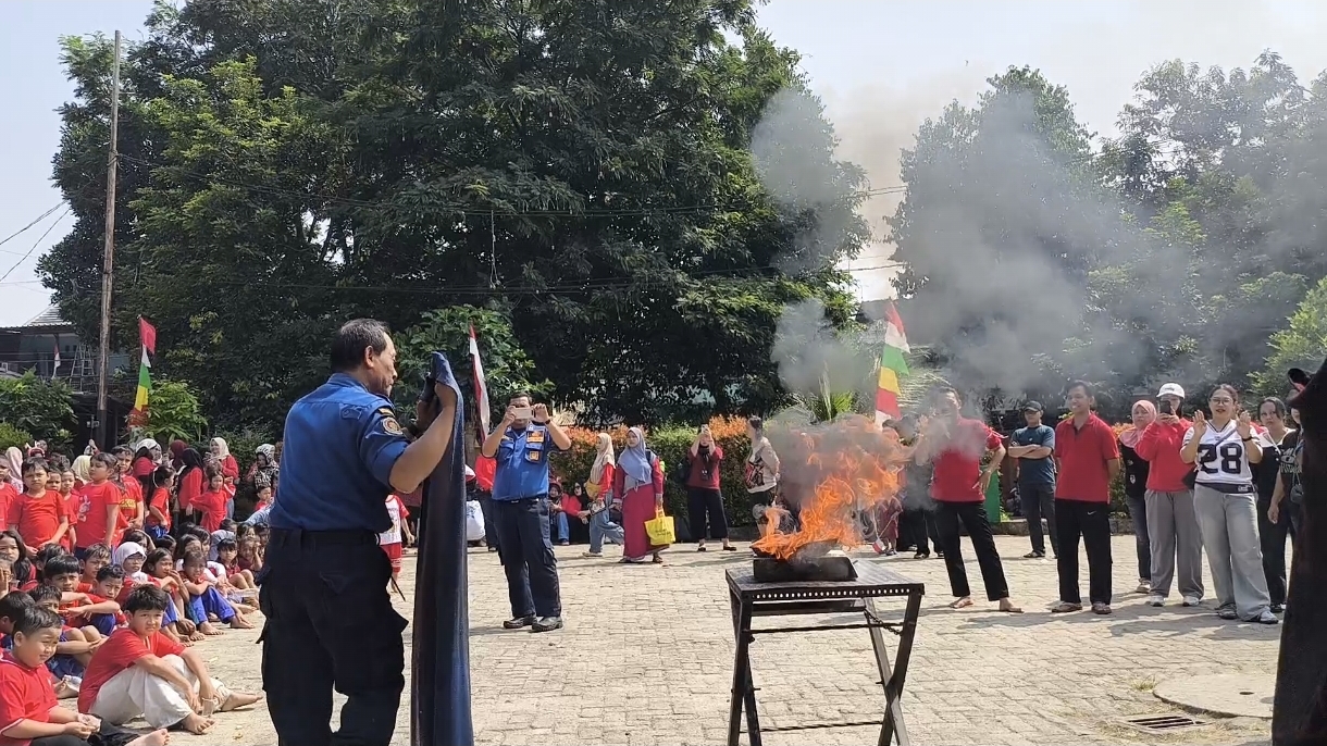 Petugas Damkar Jatinegara memperagakan teknik pemadaman api menggunakan handuk basah di hadapan siswa SDN 09 Cipinang Besar Utara Jakarta Timur